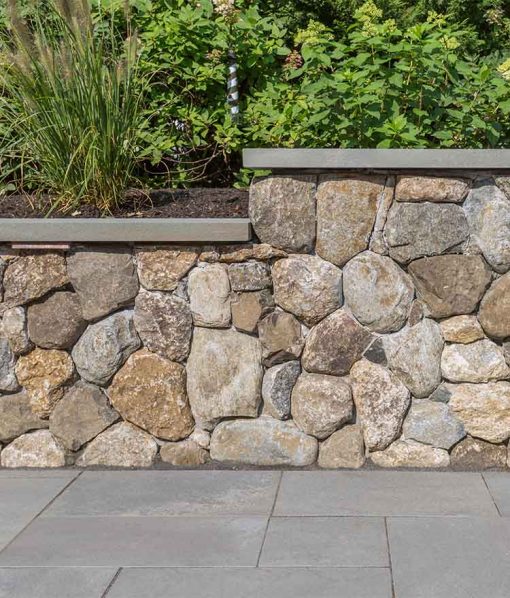 Retaining wall with round thinstone veneer on patio