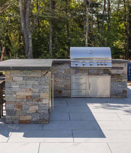 Backyard kitchen on patio with natural stone veneer