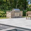 Outdoor kitchen grill with New England rounds veneer on pool patio