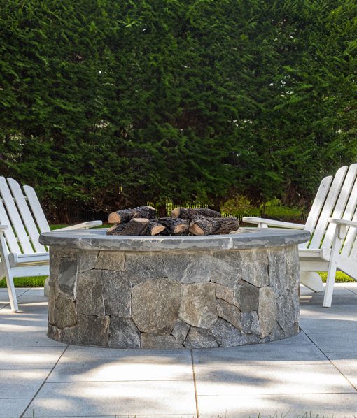 Fire pit on patio with brown and gray stone veneer