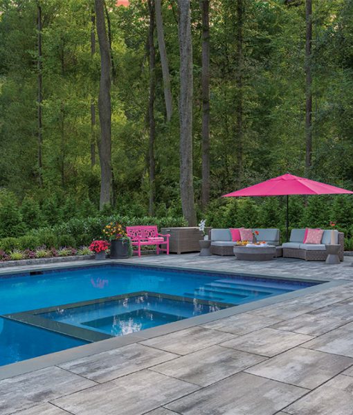 pool with pavers near forest