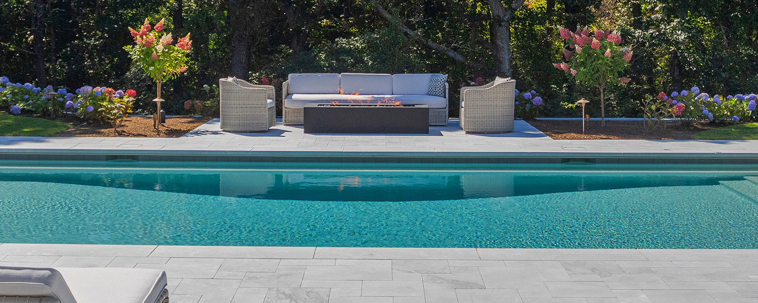 fire pit lit at a poolside on a sunny afternoon