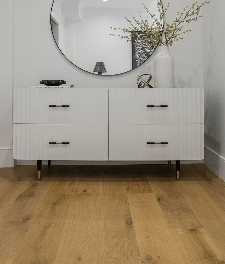 brown toned natural wood floor shown with circular mirror in boston