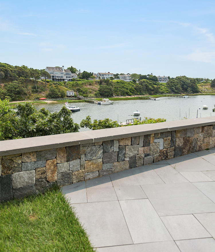 Natural square and rec thin stone veneer stone wall with an ocean view.