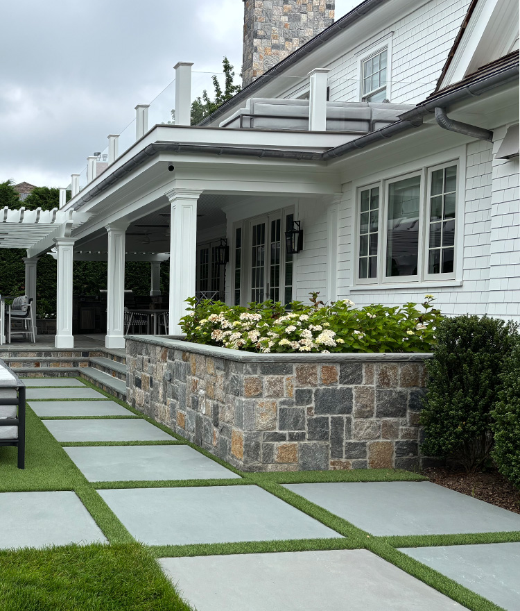 Gray and tan square and rec thin stone veneer retaining wall and stairs with flowerbeds
