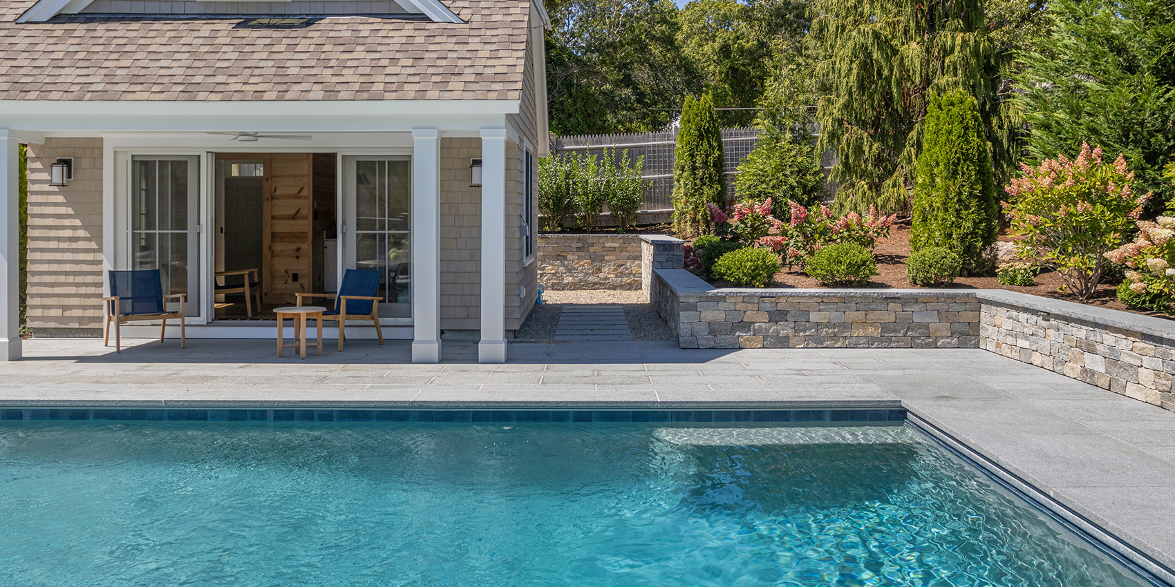 pool shown with cabana and natural softscape